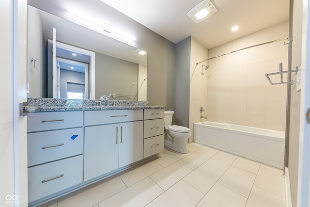 full bathroom featuring vanity, toilet, tiled shower / bath combo, and tile patterned flooring