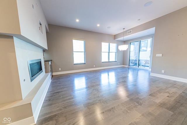 unfurnished living room with a notable chandelier and hardwood / wood-style flooring