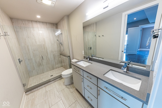 bathroom featuring vanity, toilet, and a shower with shower door