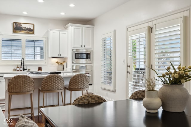 kitchen featuring sink, white cabinetry, a kitchen breakfast bar, and stainless steel appliances