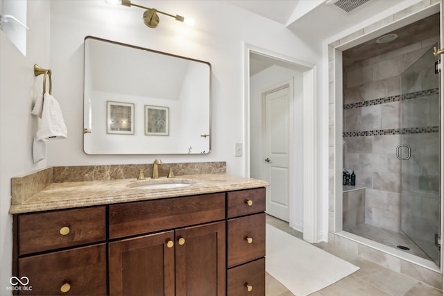 bathroom featuring vanity, a shower with shower door, and tile patterned flooring