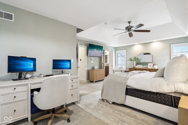 carpeted bedroom with a tray ceiling and ceiling fan