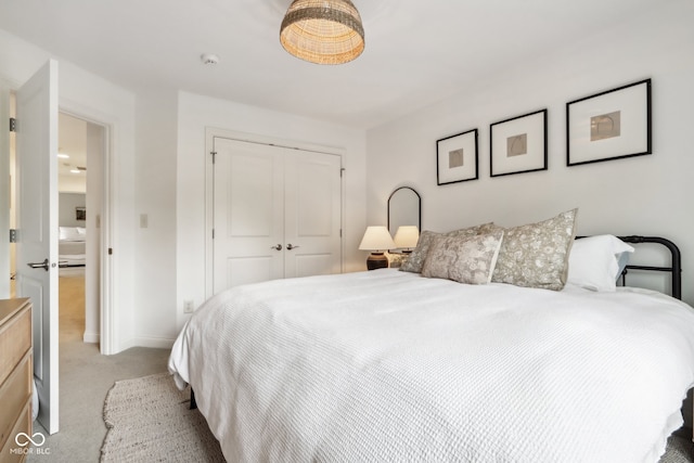 bedroom featuring light carpet and a closet