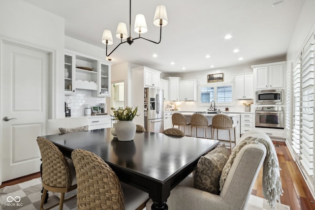 dining space featuring a notable chandelier, sink, and wood-type flooring