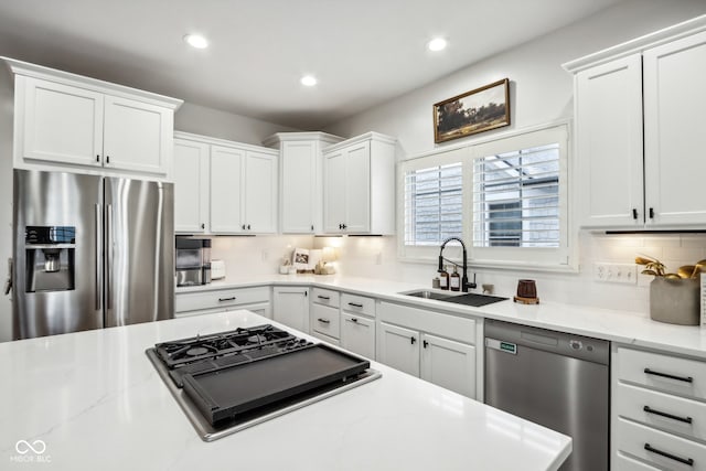 kitchen with decorative backsplash, white cabinetry, and stainless steel appliances