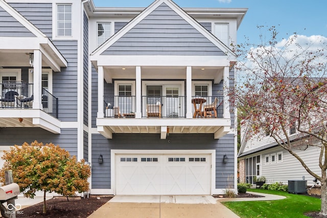 townhome / multi-family property featuring a balcony, central AC unit, and a garage