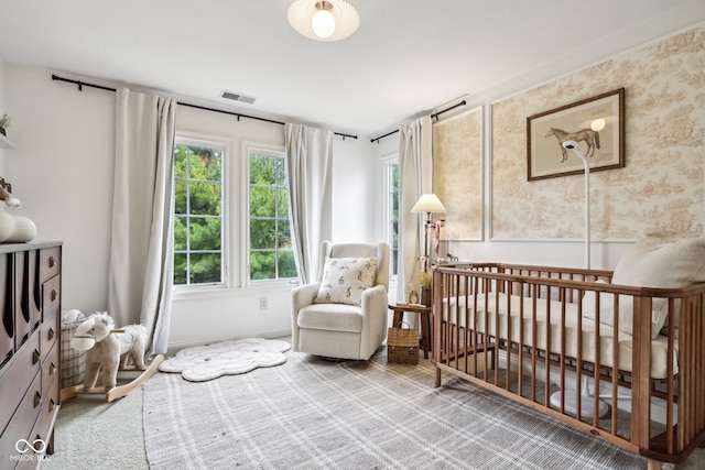 bedroom featuring carpet and a crib