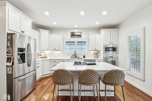 kitchen with white cabinetry, stainless steel appliances, and wood-type flooring