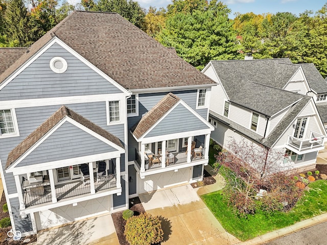 rear view of property with a garage and a balcony