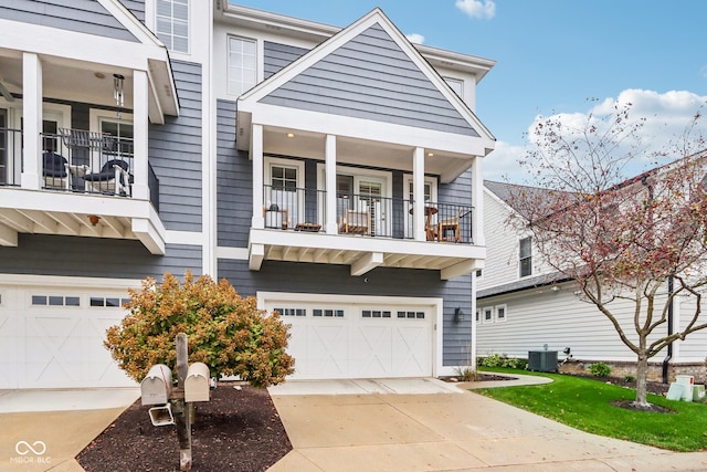 view of front of house with central AC unit, a garage, and a balcony