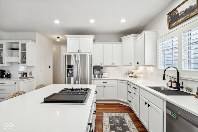 kitchen with dark hardwood / wood-style flooring, appliances with stainless steel finishes, sink, and white cabinets