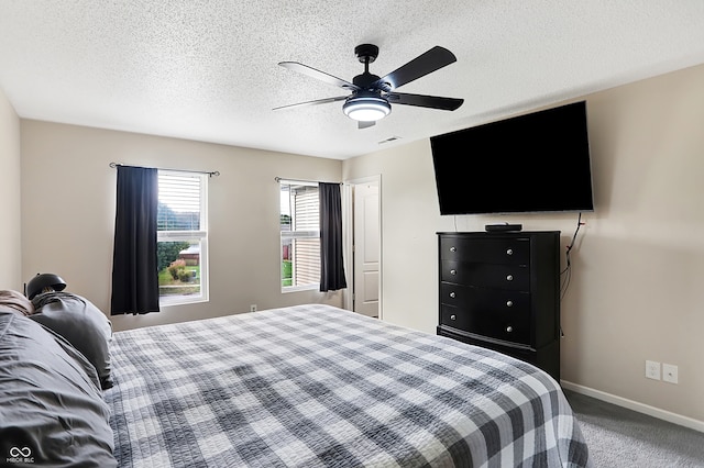 bedroom featuring ceiling fan, a textured ceiling, and carpet floors