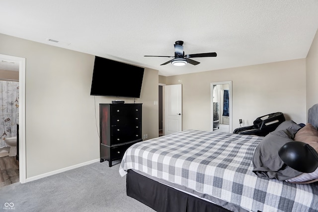 bedroom with a textured ceiling, ensuite bathroom, carpet flooring, and ceiling fan