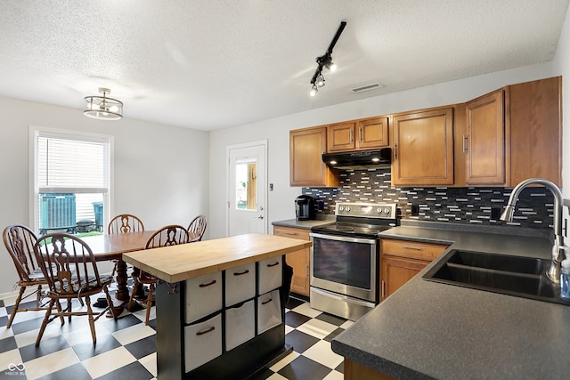 kitchen with stainless steel electric stove, a kitchen island, backsplash, a textured ceiling, and sink