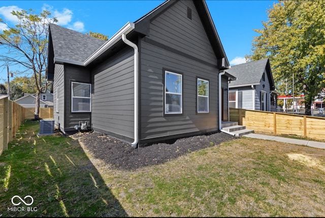 rear view of property with a yard and central AC unit