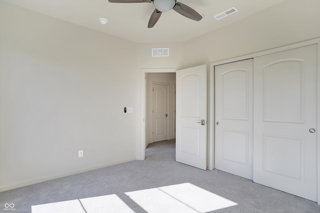 unfurnished bedroom featuring light colored carpet, a closet, and ceiling fan