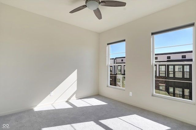 empty room featuring ceiling fan and light colored carpet