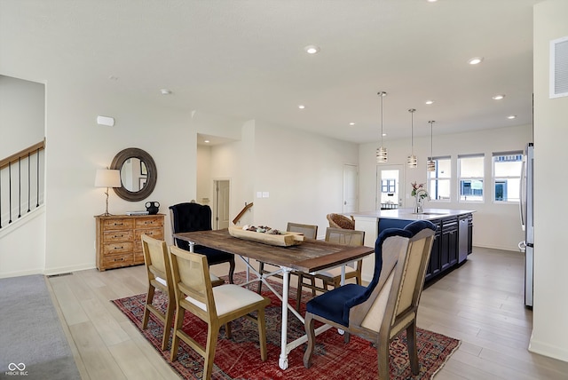 dining space with light hardwood / wood-style flooring and sink