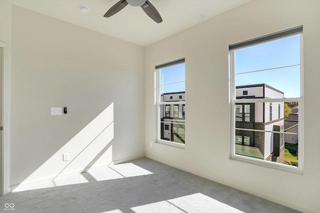 spare room with ceiling fan and light colored carpet