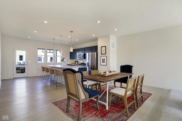 dining area with sink and light hardwood / wood-style flooring