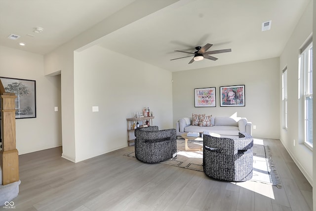 living room with light hardwood / wood-style flooring, ceiling fan, and plenty of natural light