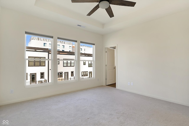 spare room with light carpet, ceiling fan, and a wealth of natural light