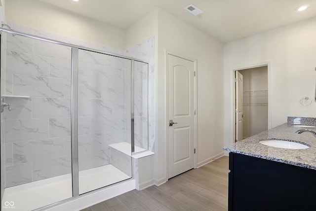 bathroom with vanity, a shower with shower door, and hardwood / wood-style flooring