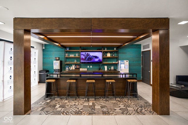 bar with beam ceiling, wooden walls, and light tile patterned flooring