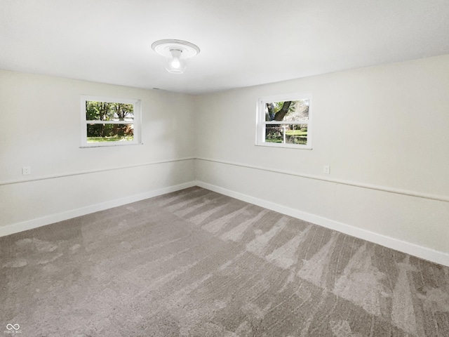 carpeted spare room with baseboards and a healthy amount of sunlight