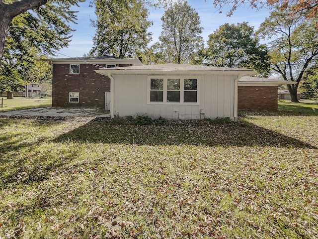 view of side of property featuring brick siding and a yard