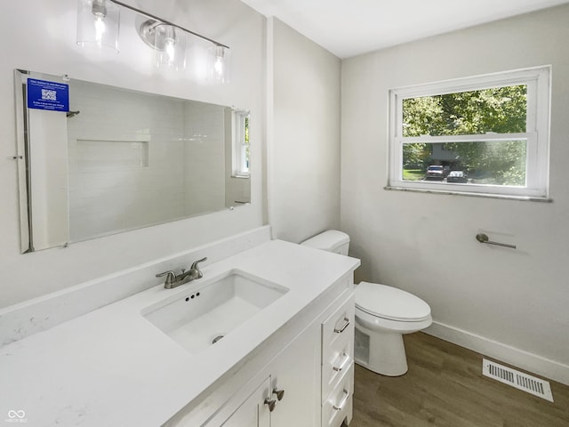 full bathroom with visible vents, wood finished floors, vanity, baseboards, and toilet