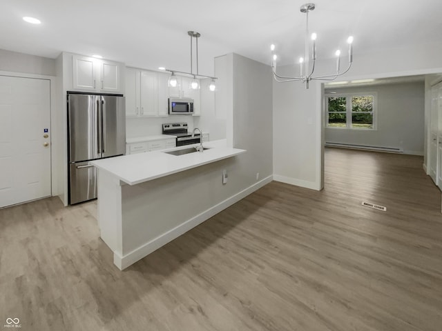 kitchen with stainless steel appliances, visible vents, light wood-type flooring, and a baseboard radiator
