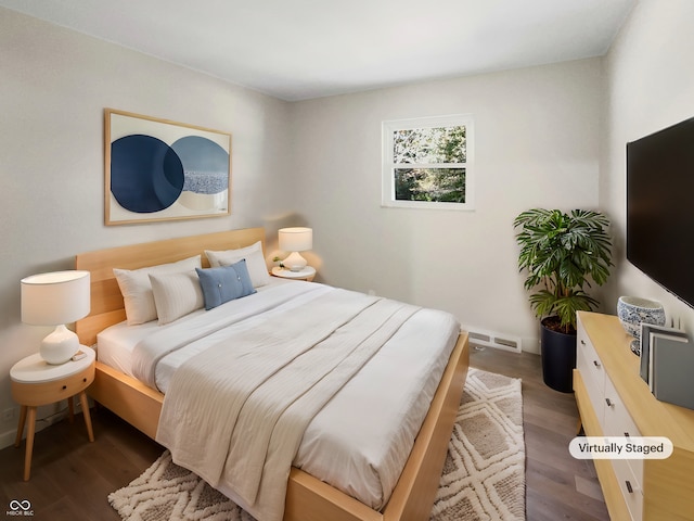 bedroom with dark hardwood / wood-style flooring