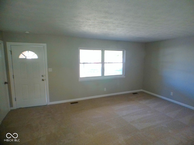 carpeted entrance foyer featuring a textured ceiling