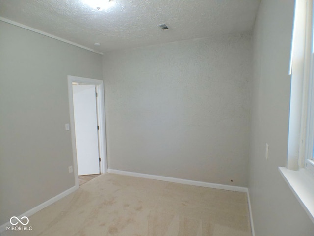 carpeted spare room with a textured ceiling