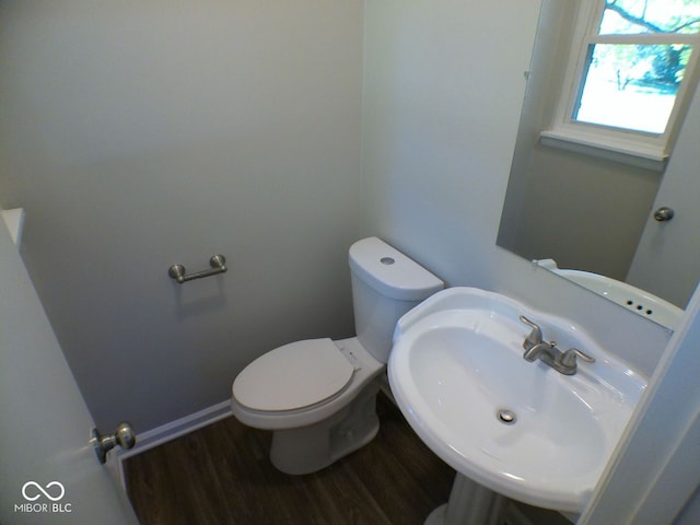 bathroom featuring toilet, sink, and wood-type flooring