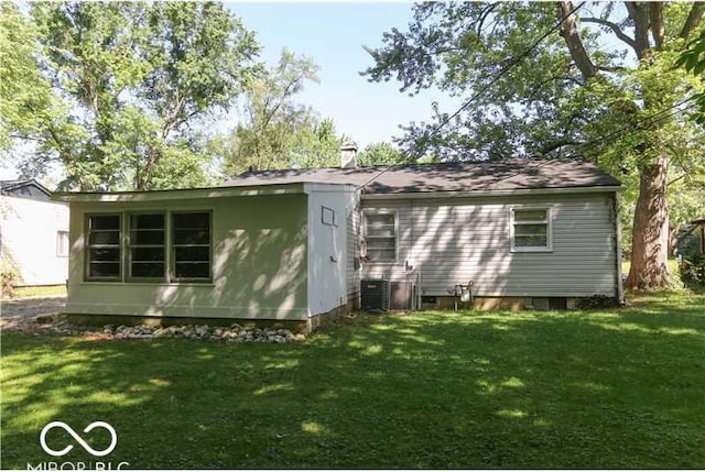 rear view of house with a lawn and central AC unit