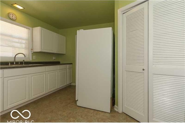 kitchen featuring sink and white cabinetry