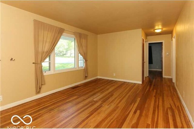 spare room with wood-type flooring