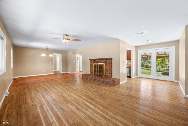 3233 Plum Creek Rd, Nashville, IN 47448 - unfurnished living room with light wood-style floors, baseboards, ceiling fan, and a brick fireplace