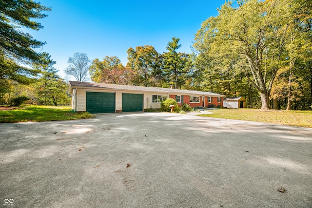 3233 Plum Creek Rd, Nashville, IN 47448 - ranch-style home featuring a storage unit, an attached garage, concrete driveway, and a front yard