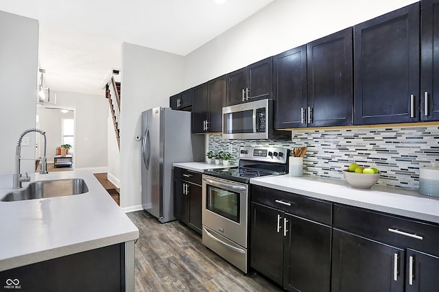 kitchen featuring dark hardwood / wood-style floors, tasteful backsplash, stainless steel appliances, and sink