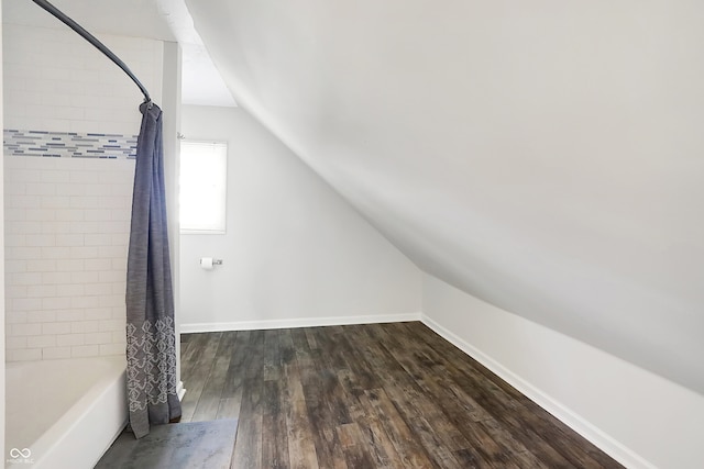 bonus room with lofted ceiling and dark hardwood / wood-style floors