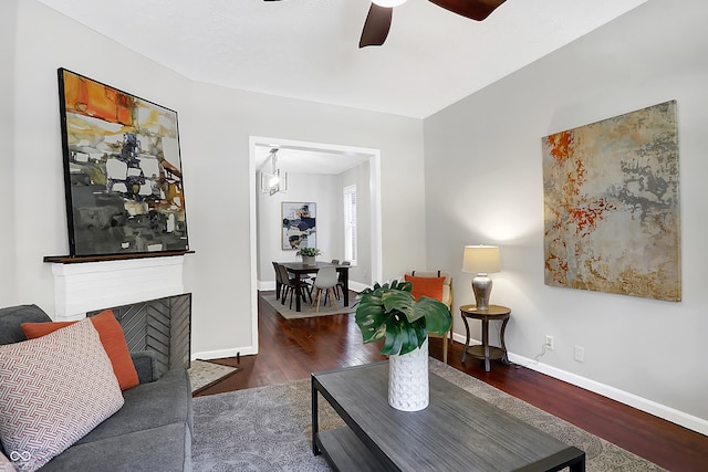 living room featuring ceiling fan and dark hardwood / wood-style floors