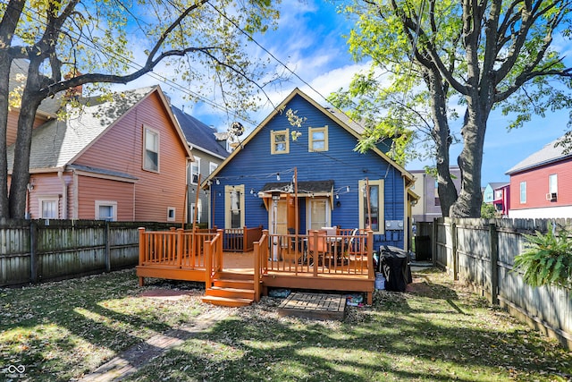 back of property featuring a wooden deck and a lawn