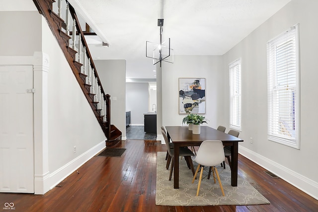 dining space featuring sink, a chandelier, and dark hardwood / wood-style flooring