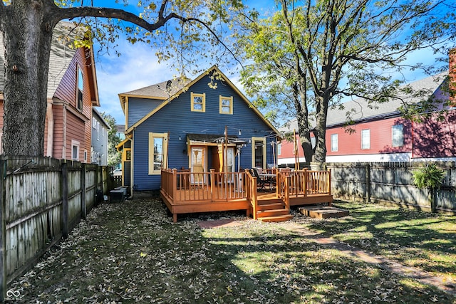 back of house featuring cooling unit, a deck, and a yard