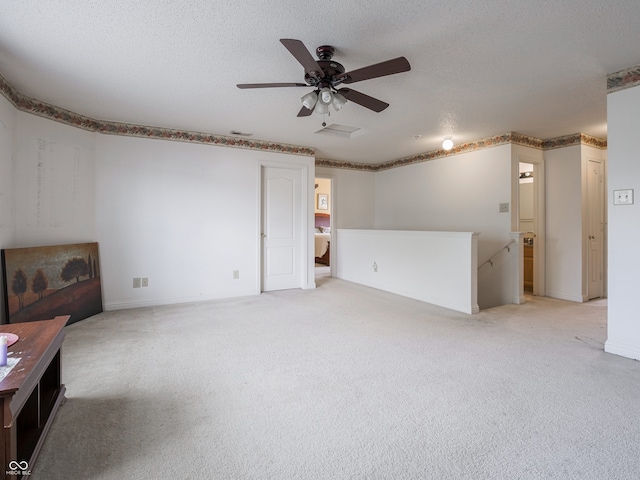 unfurnished living room featuring light carpet, a textured ceiling, and ceiling fan