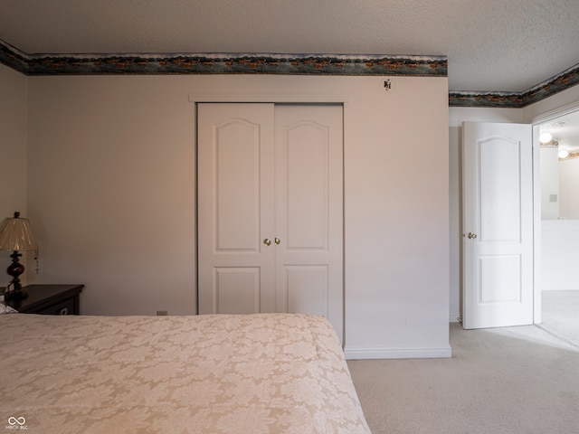 carpeted bedroom with a closet and a textured ceiling