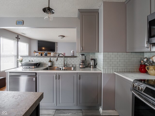 kitchen with tasteful backsplash, sink, and gray cabinetry